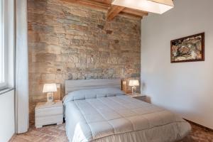 a bedroom with a stone wall and a bed at Casa Loretta Vicopisano in Vicopisano