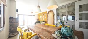a dining room with a large wooden table and yellow chairs at Vista al Mar 2 Peñiscola in Peniscola
