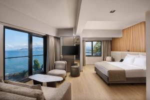 ein Hotelzimmer mit einem Bett und einem großen Fenster in der Unterkunft Waveside hotel in Altınordu