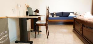 a room with a bed and a desk with a couch at Villa Mare Presepe in Torchiarolo
