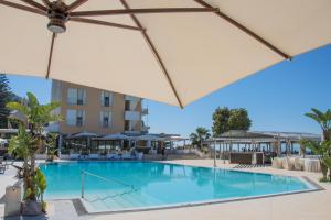 a swimming pool with an umbrella and a building at Grand Hotel Moon Valley in Vico Equense