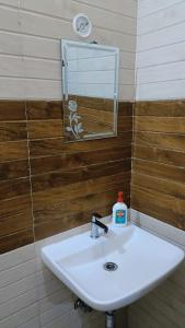 a bathroom sink with a mirror and a soap bottle at Divine Blessings Banquet and Hotel in Prayagraj +54 photos