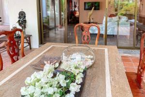 a table with a glass vase with flowers on it at Southern Lanta B9 in Ko Lanta