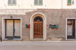 a building with a wooden door and two windows at Casa Ilaria Vicopisano in Vicopisano