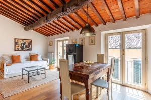 a kitchen and living room with a wooden table and chairs at Mordini Loft - 3 Bedrooms - Lucca in Lucca