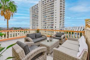 a balcony with wicker chairs and tables and a building at Paraiso Terrace Suite in Playa Paraiso +30 photos
