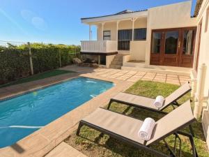 a house with a swimming pool and two lounge chairs at Winford Manor in Murdoch Valley