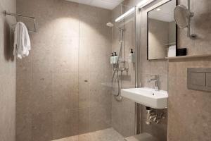a bathroom with a shower and a sink and a mirror at Scandic Neptun in Bergen +42 photos