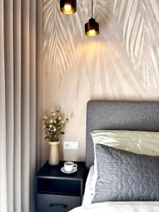 a bedroom with a bed and a table with a vase of flowers at Apartament Kaszubska Bryza III - HEL in Hel