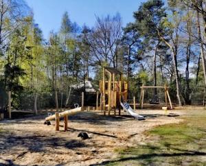 a playground with a slide and swings at Outdoors Holten - Cabin Skydeck in Holten