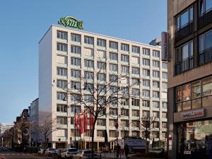 a large white building with a gold sign on top at Numa Cologne Ehrenfeld in Cologne