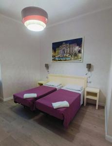 a bedroom with two beds and a large light at Hotel PRINCIPE AMEDEO in Rome