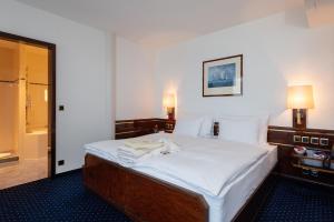 a bedroom with a large bed with white sheets at Bad Horn - Hotel & Spa in Horn