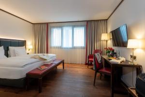 a hotel room with a bed and a desk at Bad Horn - Hotel & Spa in Horn
