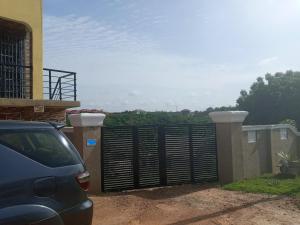 a car parked in front of a fence at Executive Apartment in Cape Coast +3 photos