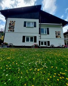 a white house with a field of flowers in front of it at Sielankowo in Wisła