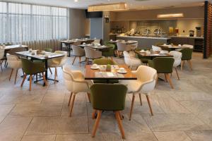 a restaurant with tables and chairs and a kitchen at City Express Plus by Marriott Tampico in Tampico