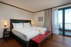 a bedroom with a large bed and a red bench at Bad Horn - Hotel & Spa in Horn