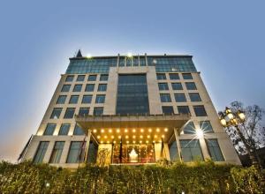 a tall building with lights in front of it at Hotel Banana Tree & Banquets 5 Min From Anand Vihar Bus Terminal and Vaishali Metro Station in Ghaziabad