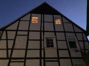 a building with lights in the windows at night at Charmantes und geräumiges Loft im DG eines Fachwerkhauses in Dortmund