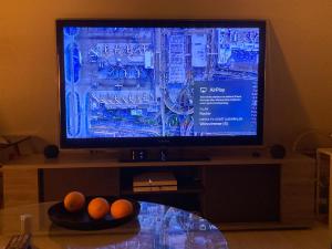 a television on a stand with oranges on a table at Charmantes und geräumiges Loft im DG eines Fachwerkhauses in Dortmund
