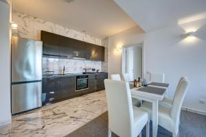 a kitchen with a table and a stainless steel refrigerator at Beach Apartments in Ulcinj +18 photos