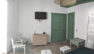 a living room with a green cabinet and chairs at La Casa di Lula in Lipari