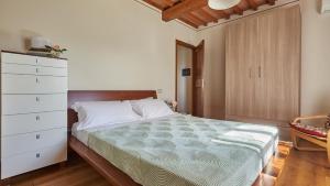 a bedroom with a large bed and a dresser at Petriolo - Tuscany Hills & Jacuzzi in Cerreto Guidi +20 photos