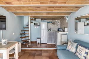 a living room with a blue couch and a kitchen at Loft Calella de Palafrugell in Calella de Palafrugell