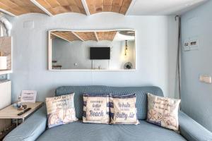 a living room with a blue couch with pillows at Loft Calella de Palafrugell in Calella de Palafrugell