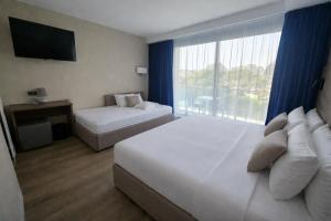 a hotel room with two beds and a large window at Hotel Europa in Quiberon