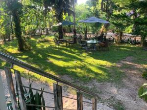 a patio with tables and umbrellas in a park at Blooming Village by Aforetime in Taling Ngam Beach