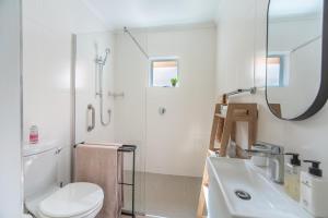 a white bathroom with a toilet and a sink at Zenith Place, Port St Francis in Cape St Francis +8 photos