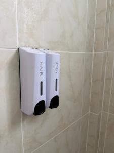 two white towels hanging on a wall in a bathroom at Laydee Resort in Chumphon