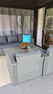 a wicker couch and a table with a bowl of flowers at Apartment in Flensburg