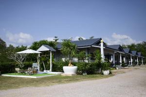 a row of houses with chairs and umbrellas at Laydee Resort in Chumphon