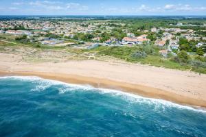 an aerial view of a beach with houses at Hotel L'Oceane in La Cotinière