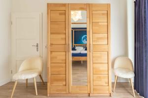 a wooden door in a room with two chairs at SEASIDE APARTMENTS - BEACHHOUSE SKY in Eckernförde