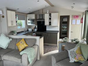 a living room with two couches and a kitchen at Hares Haven pet friendly sleeps 6 in Patrington