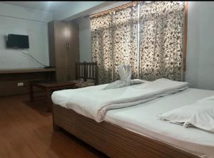a bedroom with a bed and a desk and a television at Hotel imroz in Srinagar