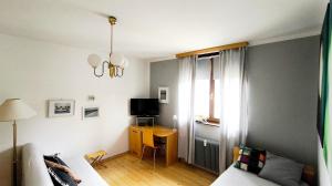a bedroom with a bed and a desk with a television at Comfy and central with bikes in Bohinj