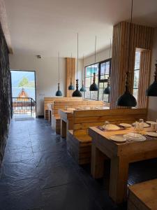 a dining room with wooden tables and pendant lights at Evri Hotel & Resorts in Lava