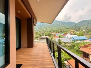 a balcony of a house with a view of the mountains at Westkey Kamala Hotel in Kamala Beach