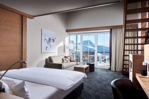 a hotel room with a bed and a chair at Panoramahotel Oberjoch in Bad Hindelang +76 photos