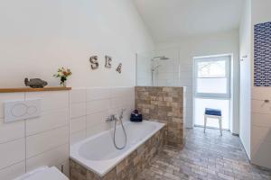 a bathroom with a tub and a toilet at SEASIDE APARTMENTS - BEACHHOUSE SKY in Eckernförde