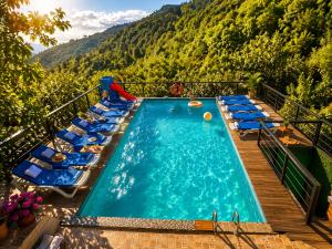 a swimming pool with lounge chairs and a mountain at Villa Provance & Swimming Pool in Sighnaghi