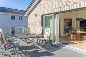 a patio with chairs and a table on a deck at SEASIDE APARTMENTS - BEACHHOUSE SKY in Eckernförde