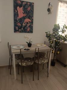 a dining room table and chairs with a painting on the wall at La conchiglia in Motta San Giovanni +14 photos