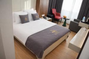 a hotel room with a bed and a red chair at Casa Ayris Boutique Hotel in Mersin