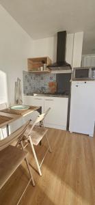 a kitchen with a table and a table and chairs at Studio Indépendant au calme in Cugand
